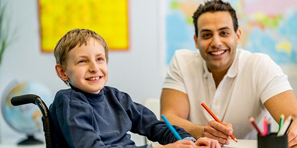 Student in wheelchair with teacher in classroom