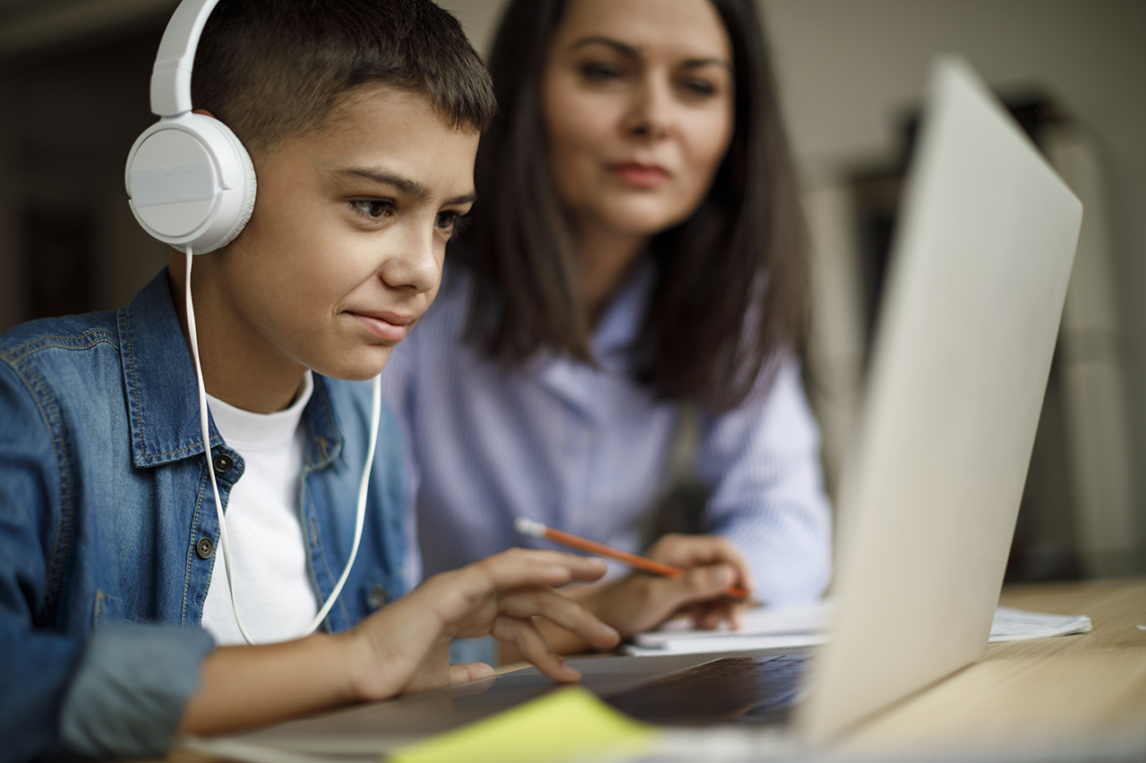 Mother and son using laptop at home