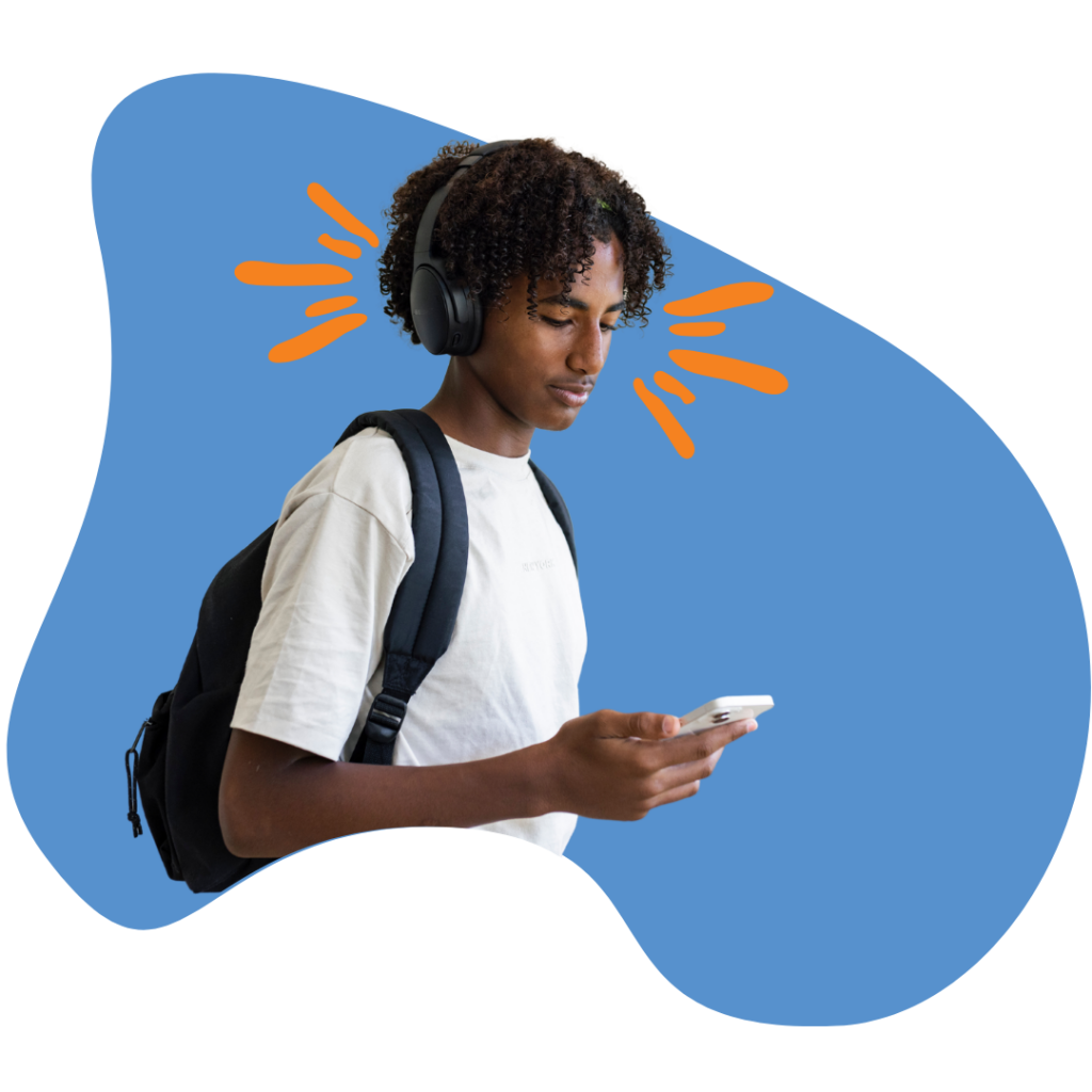 Male teen with curly hair and black backpack reading on mobile phone with headphones on.